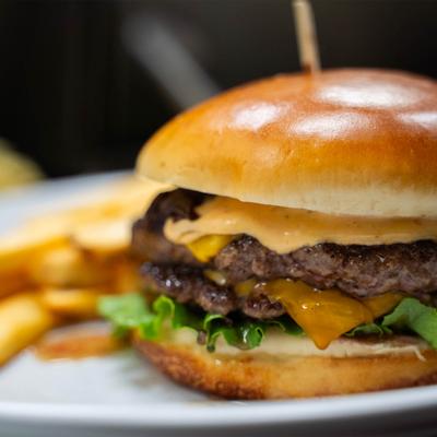 Double smashed burger with melted cheese and fries.