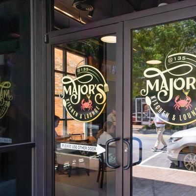 Restaurant glass entrance doors featuring window decals.