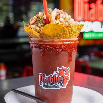 Michelada topped with shrimp aguachile and tortilla chips.