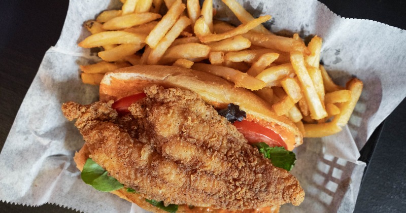 Fried fish sandwich with fries, top view