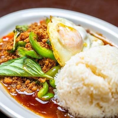 Gaprow Pork topped with fried egg, served wih rice, close-up.