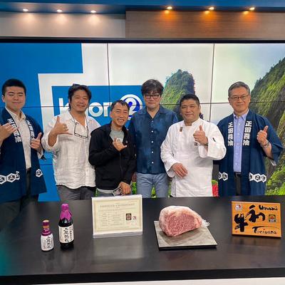 Team posing for a picture in a TV studio.