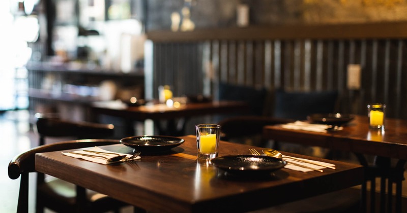 Interior detail, a table with tableware, glass candle and cutlery