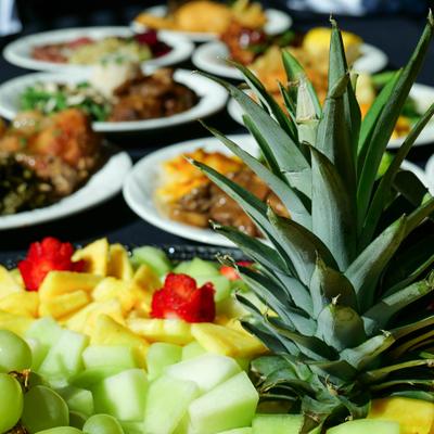Fresh seasonal fruit tray with other dishes on the table.