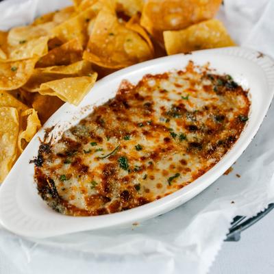Spinach and artichoke dip with chips, close up.