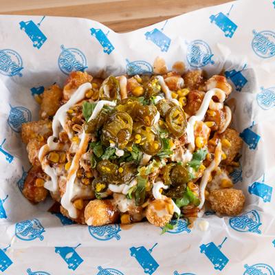 Tater tots with pulled pork, BBQ sauce, cheese, lettuce, corn, sour cream, and jalapenos.