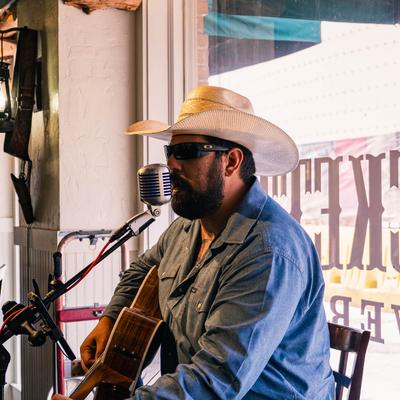 A person singing and playing the acoustic guitar.
