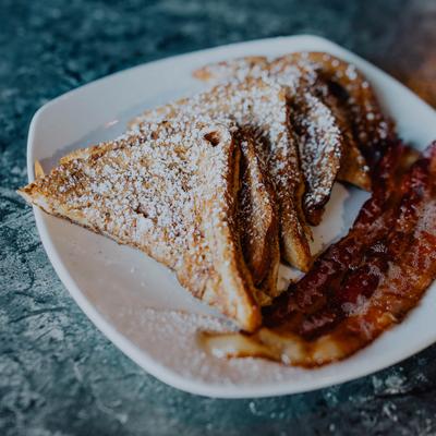 French toast with powdered sugar and crispy bacon.