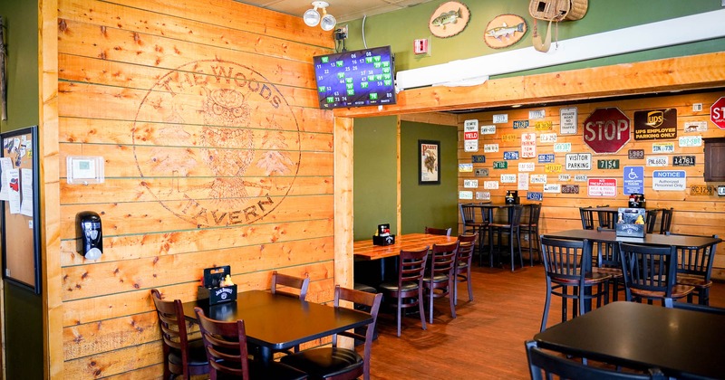 Interior, seating area with tv above tables and chairs