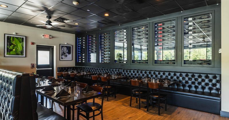 Modern restaurant interior with wine display and black leather seating