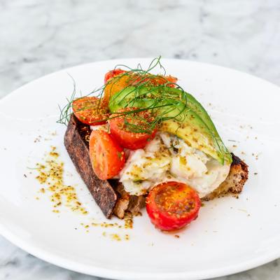 Crab Toast topped with avocado and cherry tomatoes