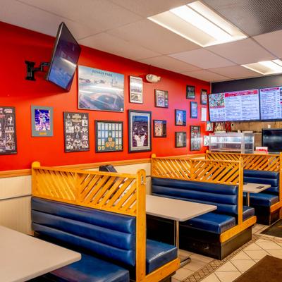 Interior with blue vinyl booths separated by wooden dividers and decorated walls.