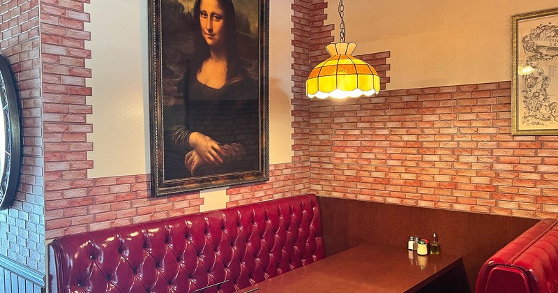Interior, dining booths near wall with picture
