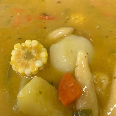 Chicken soup with corn and vegetables, close up.
