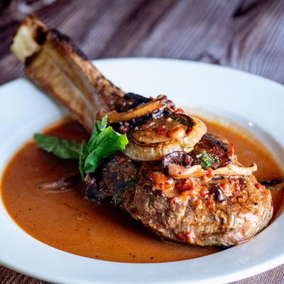 Pork chop in mushroom sauce, with grilled onions.