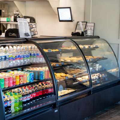 Refrigerated display case with assorted pastries and drinks.
