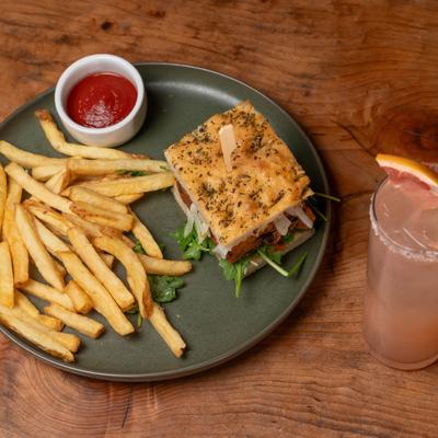 Veggie burger with fries and a drink.