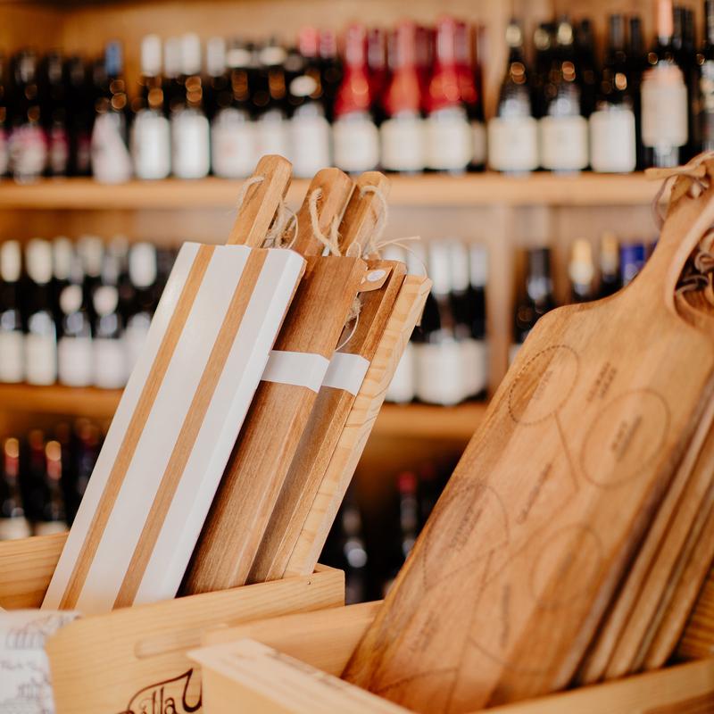Wooden cheese cutting boards and charcuterie trays displayed in a shop.