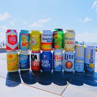 A group of beer cans neatly arranged on a wooden table.