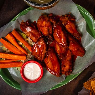 Chicken wings with carrots and a sauce.