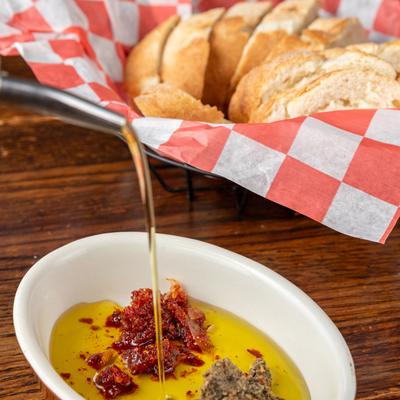 Bread in a bread basket, olive oil in small dipping bowl.