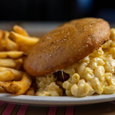 Macaroni and cheese burger served with French fries.