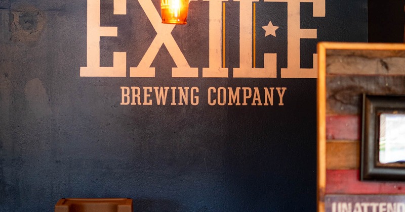 Interior wall decorated with words reading Exile Brewing Company