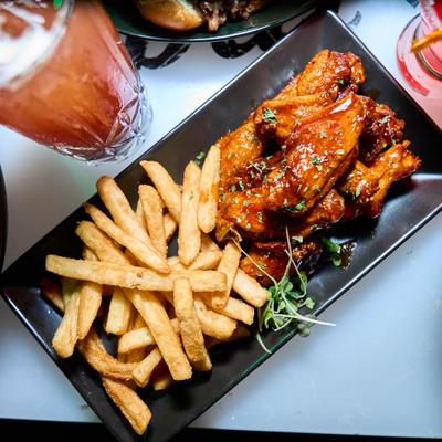 Spicy BBQ wings with fries and a drink.
