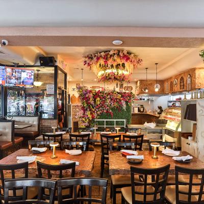 Dining area with tableware on tables and chairs.