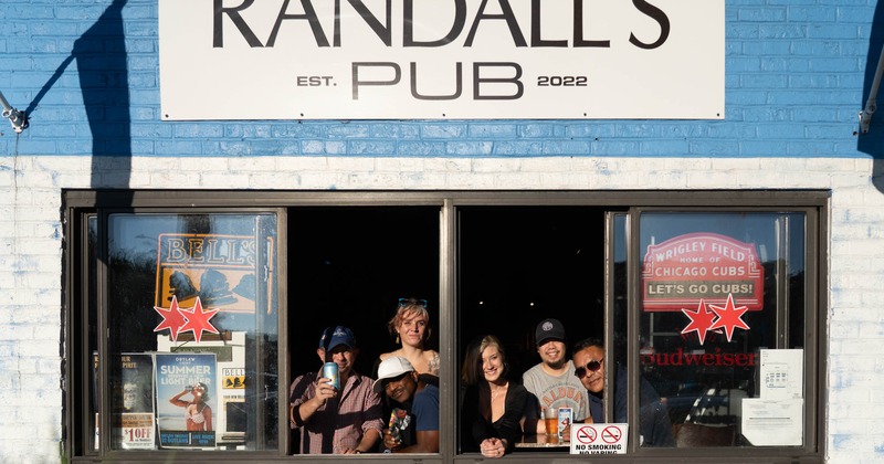 Exterior, restaurant front, patio, seating area, lavish plant decoration, painted brick wall