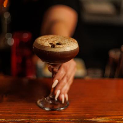 A hand holding the espresso martini.