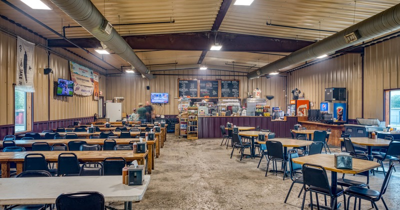 Interior, lined up tables and chairs, bar in the back