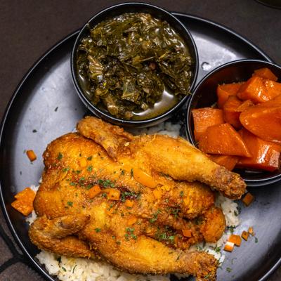Fried Cornish Hen with sides, top view.