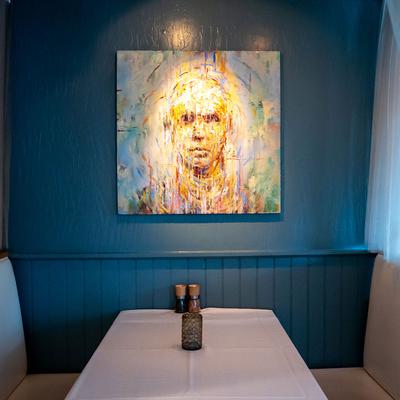 Interior, private seating and table with a painting on the wall.