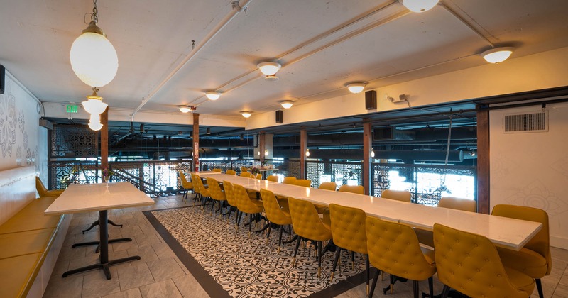 Interior, private room, long table with yellow leather chairs, banquette bench, tile flooring