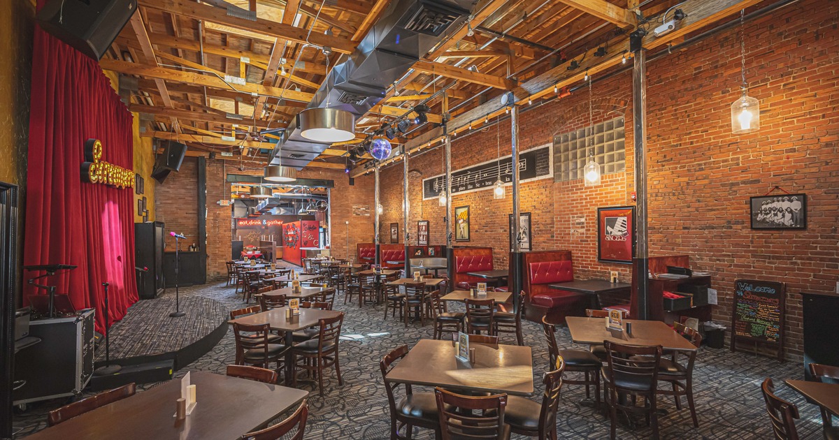Interior, room with dining tables and booths and a music stage