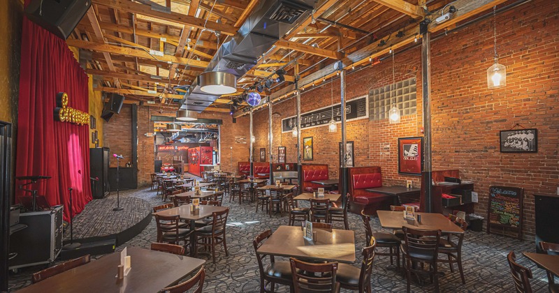 Interior, room with dining tables and booths and a music stage