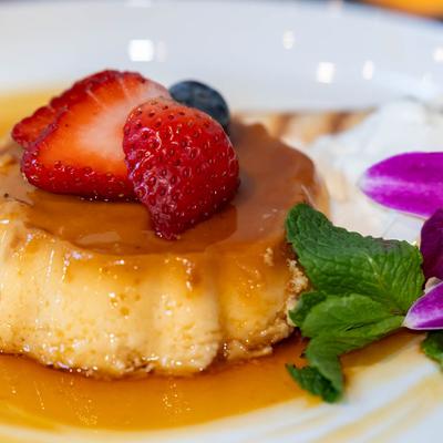 Flan with strawberries, blueberries, mint, and flowers.