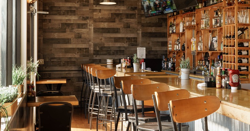 Interior, bar area, bar with stools, large wooden drink rack, wood coated walls