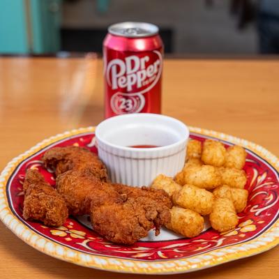Chicken tenders with side of tater tots and dip, served with can of soft drink.
