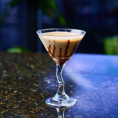 Tiramisu Martini served in a z-stem glass on a table.