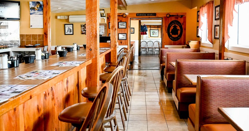 Interior, bar area, tables and seating benches on the right, bar and bar stools on the left