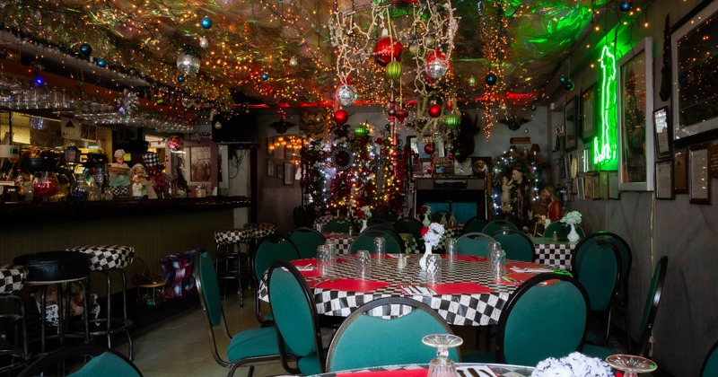 Festively decorated restaurant interior with lights and green chairs