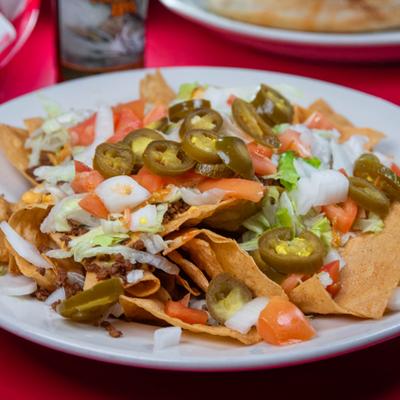 Loaded Nachos topped with ground beef, cheese, lettuce, tomatoes and jalapenos.