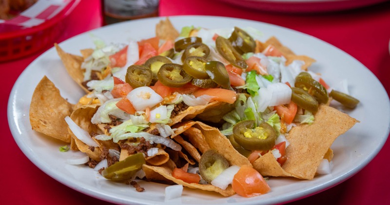 Loaded Nachos topped with ground beef, cheese, lettuce, tomatoes and jalapenos