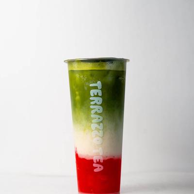 A vibrant drink in a tall, clear cup with green, white, and red layers.