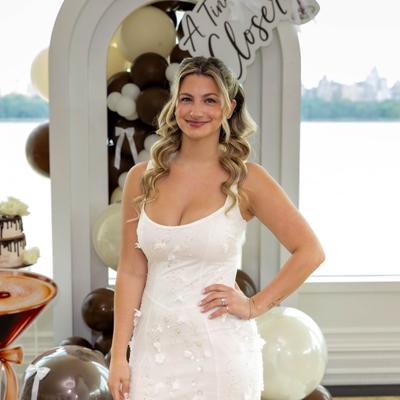 Bride posing beside a white and brown balloon display.