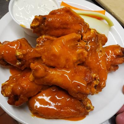 Hot chicken wings, served with carrots, celery, and blue cheese dressing.