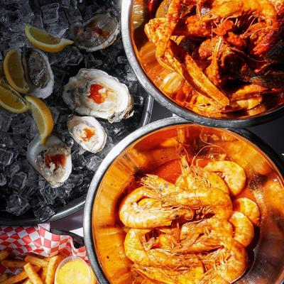 Cajun-style seafood boil served alongside fresh oysters over ice.