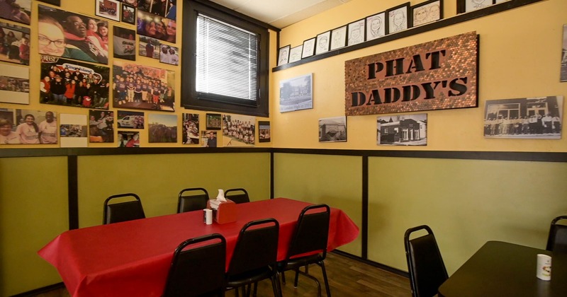 Interior of a restaurant featuring a red table with condiments, surrounded by black chairs